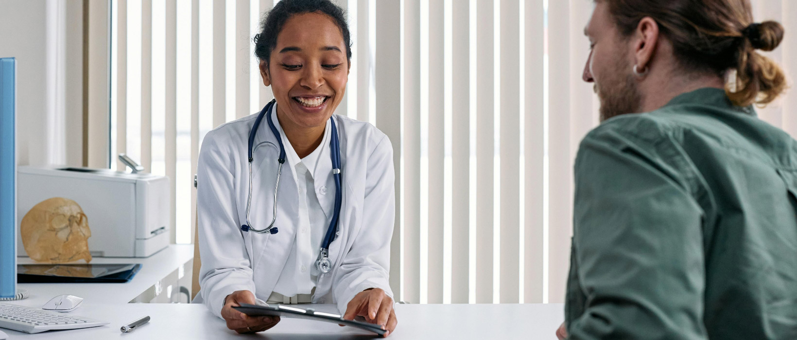 A woman doctor is check-in patient reports with a smile