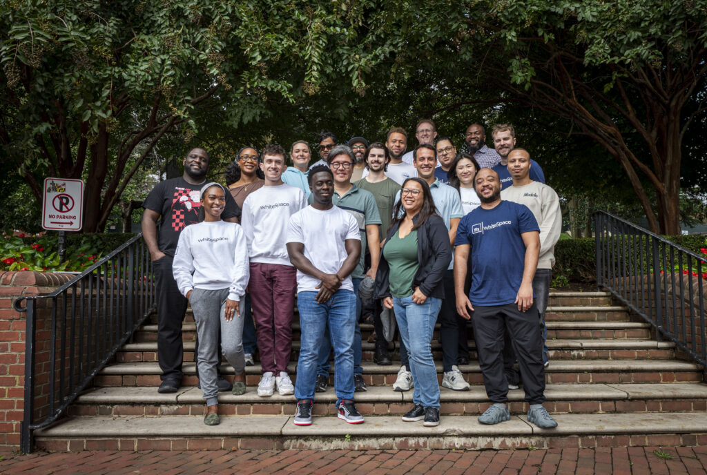 WhiteSpace team members stand on stairs